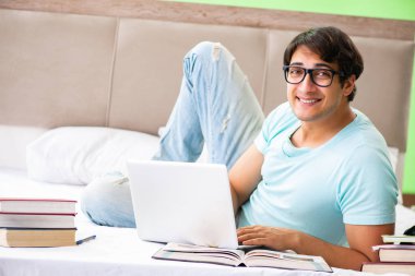 Sınavlara hazırlanan öğrenci yatak odasında yatağa uzanıyor.