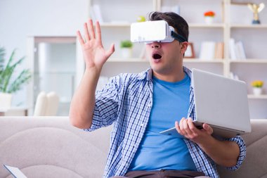 Evde sanal gerçeklik gözlükleriyle serbest çalışan bir öğrenci.