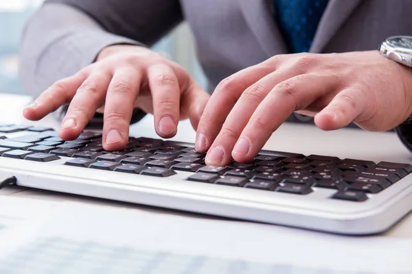 Finance professional working on keyboard with reports — Stock Photo, Image
