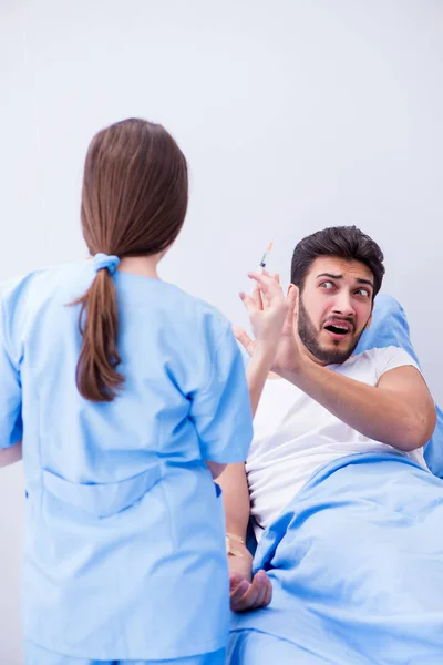 Vrouwelijke arts onderzoekt mannelijke patiënt in het ziekenhuis — Stockfoto