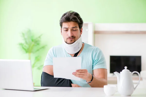 Young student man with neck and hand injury at home — Stock Photo, Image