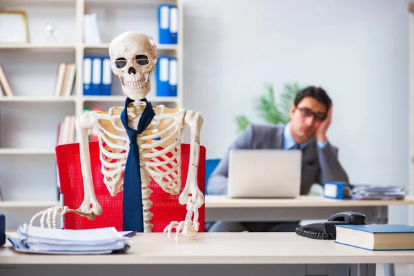 Businessman working with skeleton in office — Stock Photo, Image