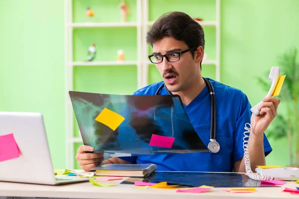 Young doctor sitting in hospital with many conflicting prioritie — Stock Photo, Image