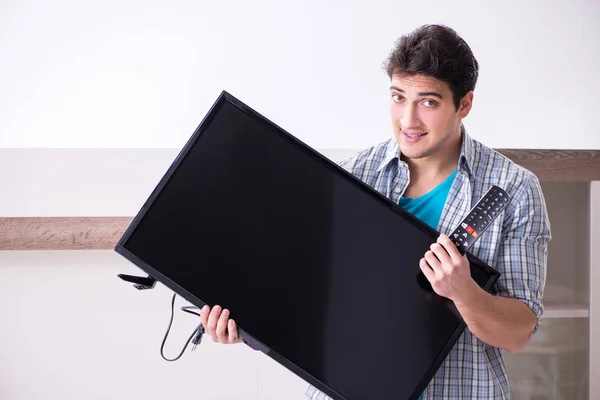 Man trying to fix broken tv — Stock Photo, Image