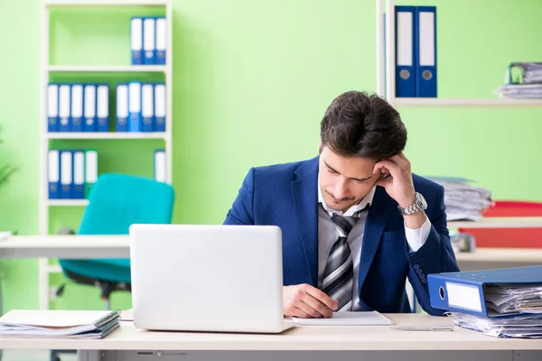 Businessman unhappy with excessive work sitting in the office — Stock Photo, Image