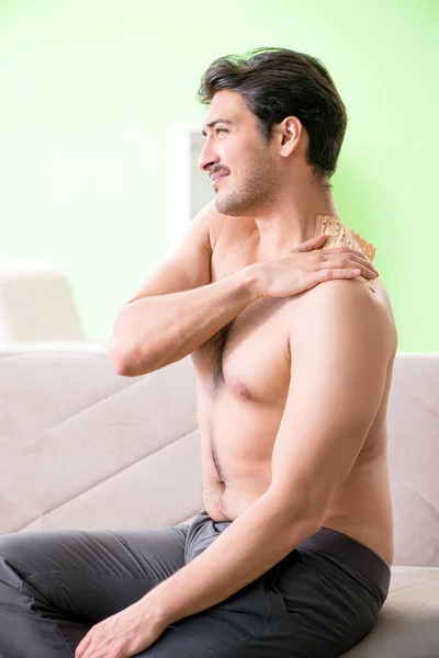Mężczyzna nakłada plaster pieprzowy Capsicum łagodzić ból — Zdjęcie stockowe