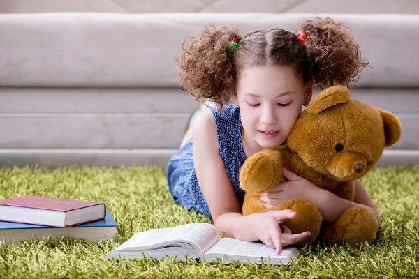 Klein mooi meisje die thuis boeken leest — Stockfoto