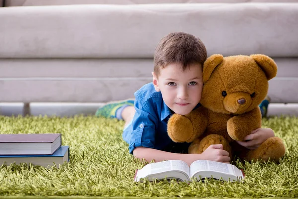 Menino pequeno lendo livros em casa — Fotografia de Stock