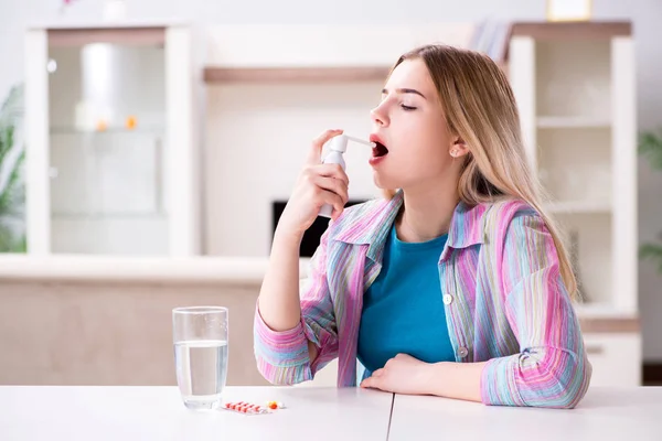 Młoda kobieta stosująca inhalator w leczeniu astmy — Zdjęcie stockowe