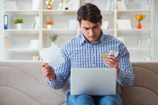 Jongeman zittend op de bank met pillen en recept — Stockfoto