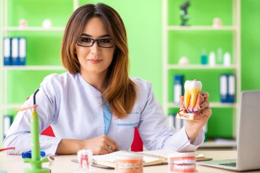 Diş implantı üzerinde çalışan kadın dişçi.