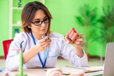 Diş implantı üzerinde çalışan kadın dişçi.