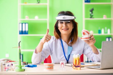 Diş implantı üzerinde çalışan kadın dişçi.