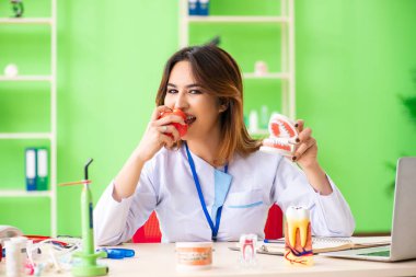 Diş implantı üzerinde çalışan kadın dişçi.