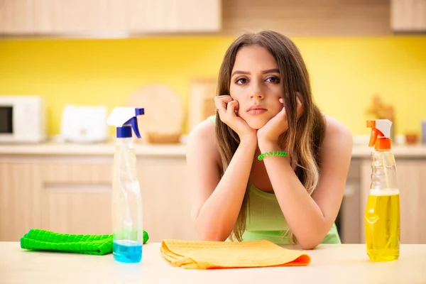 Молода блукаюча жінка полірує стіл на кухні — стокове фото