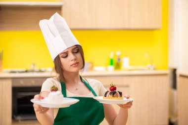 Genç aşçı mutfakta kek pişiriyor.