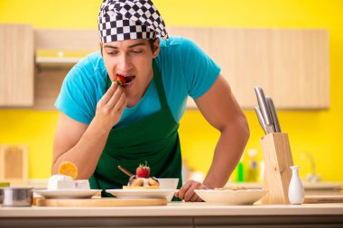 Adam evde pasta hazırlıyor.