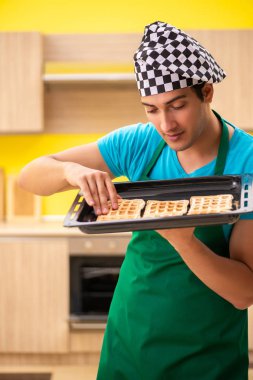 Adam evde pasta hazırlıyor.