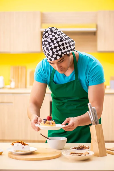 Человек готовить торт на кухне дома — стоковое фото