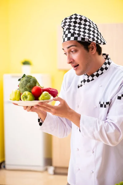 Jovem cozinheiro profissional preparando salada em casa — Fotografia de Stock