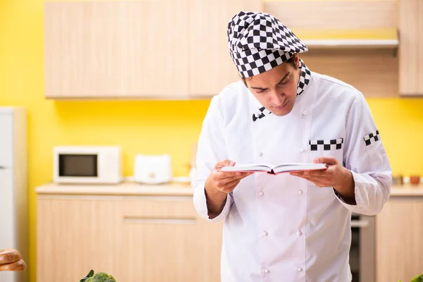Jovem cozinheiro profissional se preparando na cozinha — Fotografia de Stock