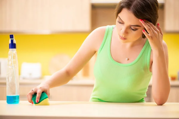 Jovem mulher beatifull polimento mesa na cozinha — Fotografia de Stock