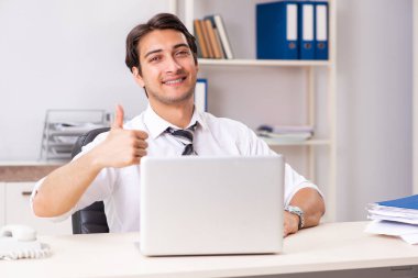 Genç yakışıklı işadamı ofiste çalışıyor.