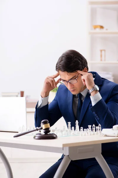 Joven abogado jugando ajedrez para entrenar su estrategia de corte y tacti — Foto de Stock