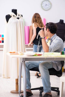 Atölyesinde çalışan genç terzi.