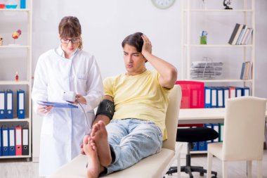 Genç doktor hastaların tansiyonunu ölçüyor.