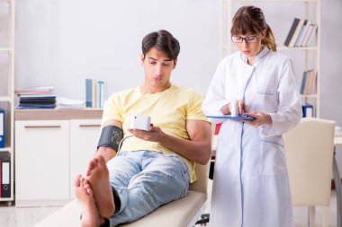 Genç doktor hastaların tansiyonunu ölçüyor.