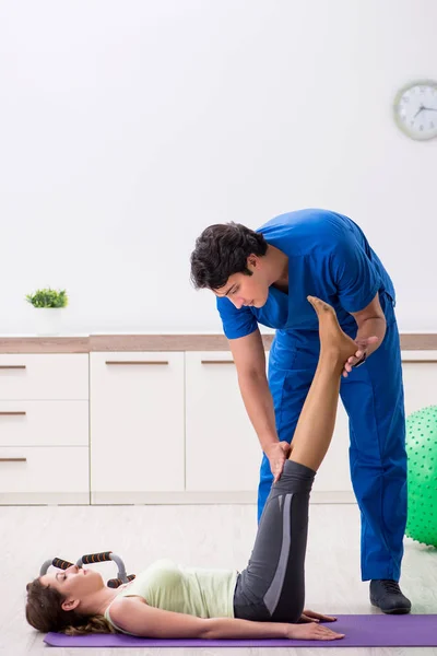 Fitness instructor helping sportsman during exercise — Stock Photo, Image