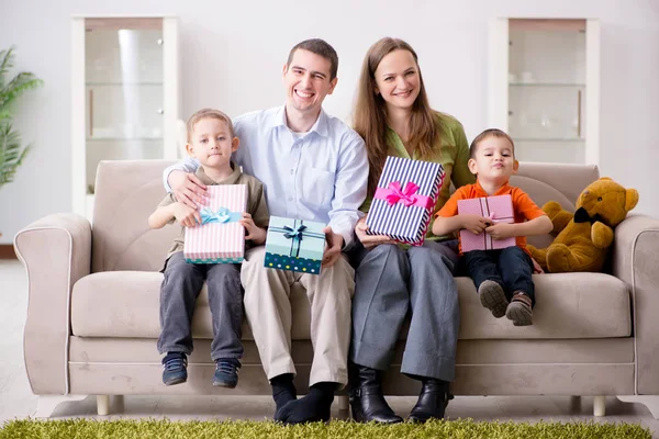 Padres jóvenes repartiendo regalos de Navidad en casa — Foto de Stock