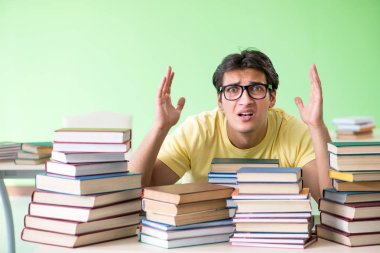Sınavdan önce okumak için çok fazla kitabı olan öğrenci