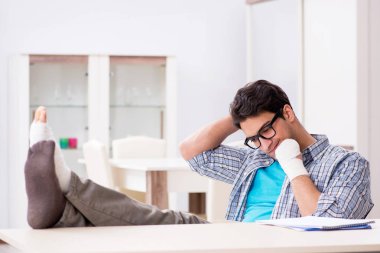 Eli yaralı genç bir öğrenci sınavlara hazırlanıyor. 