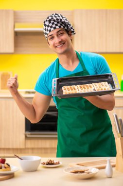 Adam evde pasta hazırlıyor.