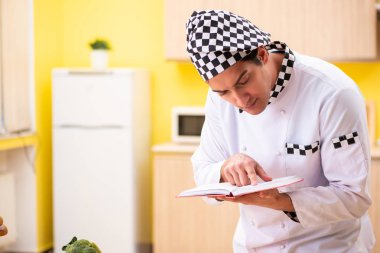 Genç profesyonel aşçı mutfakta hazırlanıyor.