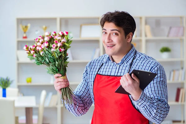 Asistente de floristería ofreciendo un ramo de flores — Foto de Stock