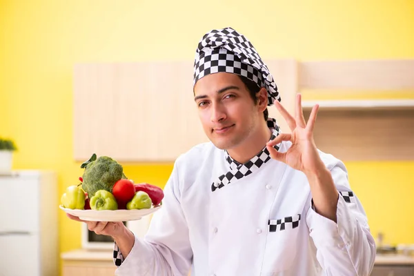 Молодой профессиональный повар готовит салат на дому — стоковое фото