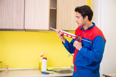 Repairman working in the kitchen  clipart