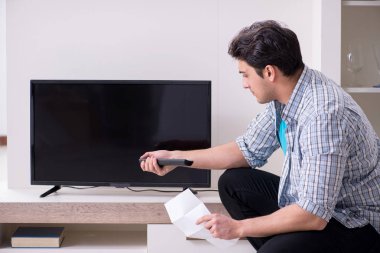 Bozuk televizyonu tamir etmeye çalışan adam