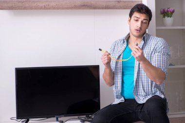 Bozuk televizyonu tamir etmeye çalışan adam