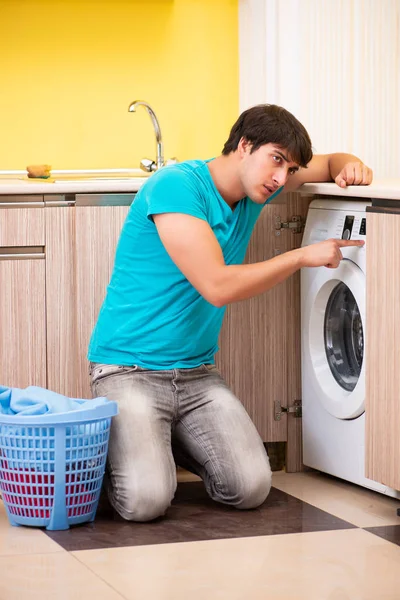 Jonge man doet de was thuis — Stockfoto