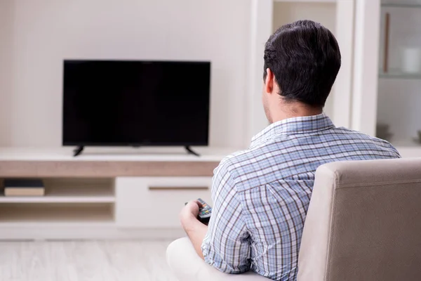 Jeune homme regardant la télévision à la maison — Photo