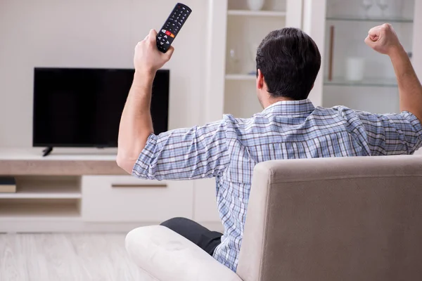 Jeune homme regardant la télévision à la maison — Photo