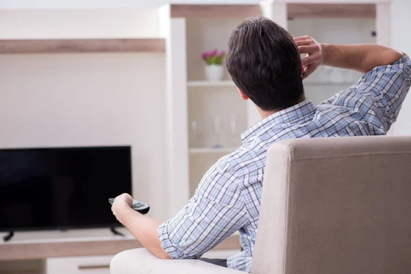 Jeune homme regardant la télévision à la maison — Photo