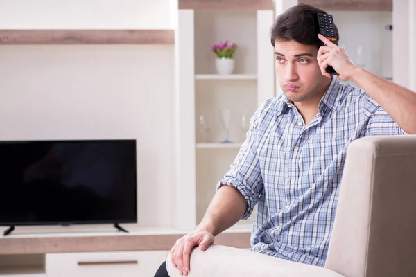 Jeune homme regardant la télévision à la maison — Photo