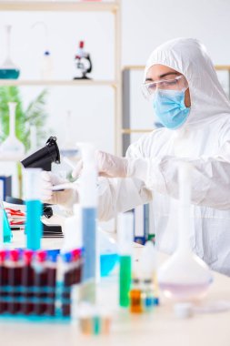 Laboratuvarda kimyasallar üzerinde çalışan genç bir kimyager.