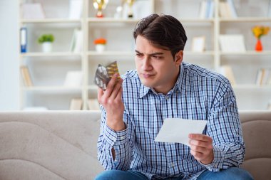 Kanepede ilaç ve reçeteyle oturan genç adam. 