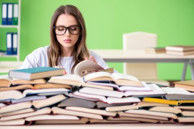 Sınavlara bir sürü kitapla hazırlanan genç kız öğrenci. 